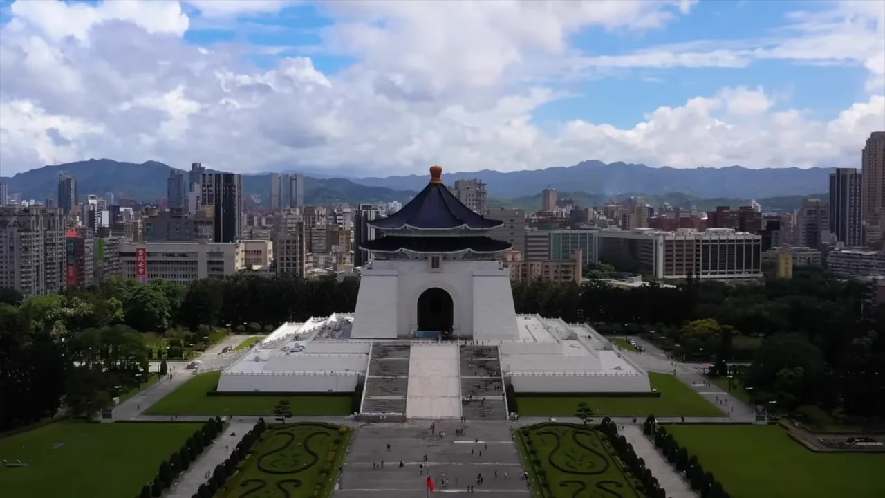 Aerial view of China’s traditional gate complex overlooking a city skyline and mountains
