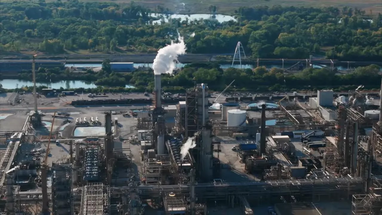 Aerial view of an oil refinery with large industrial structures and steam emissions used in US sanctions explanation