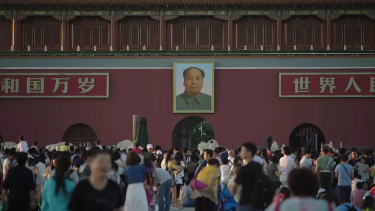 People walking in front of a Mao portrait at Tiananmen Gate in Beijing