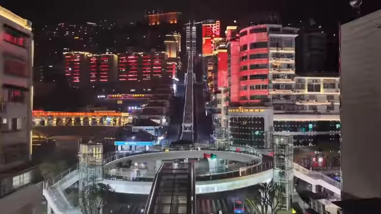 Chongqing night scene with an escalator structure spanning a multi-level roadway area