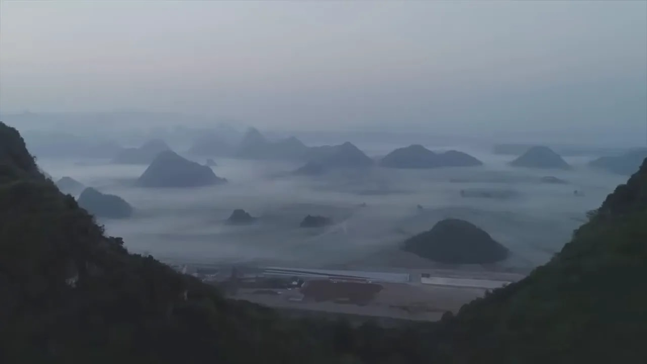 Hazy coastal landscape with islands and cargo ships in the distance