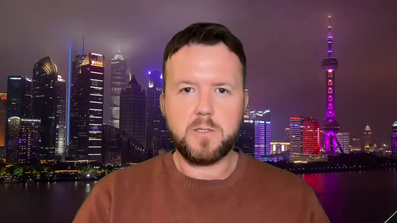 Presenter discussing China tightening the tax net in front of the Shanghai skyline at night