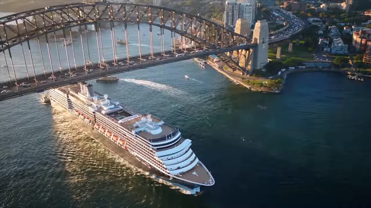 A ship sailing through a river near an arch bridge, illustrating shipping and energy supply routes for Australia and China